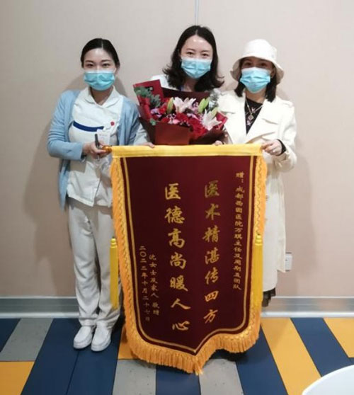 患者与万琪医生合影，送上锦旗